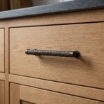 Columna de volutas en mueble de madera en bronce envejecido